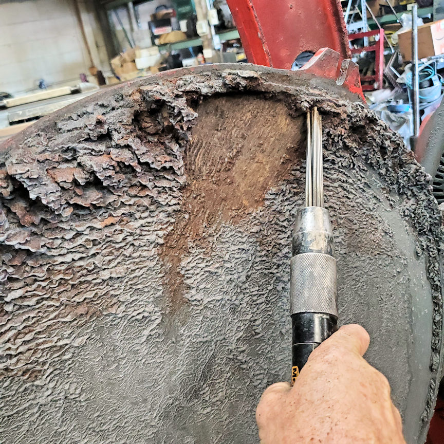 202610 – crankwheel clean Hand using a rotary tool to clean a rusted metal surface